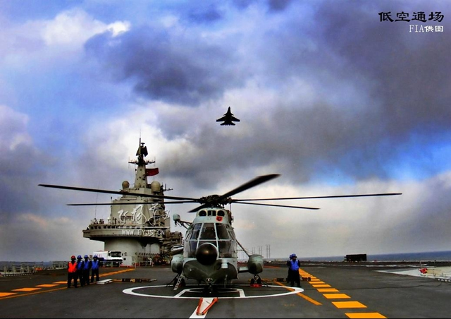 A Chinese Navy Shenyang J-15 carrier based fighter aircraft flies over a Z8 Helicopter