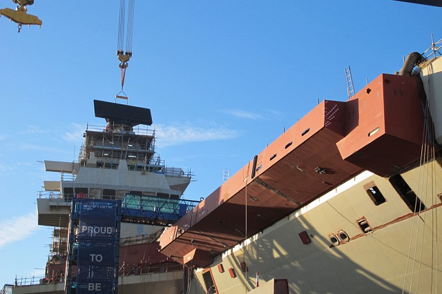 The Royal Navy’s future flagship now stands 56 metres (183ft) tall – higher than Nelson’s Column – after the enormous Goliath crane lifted the 8.4-tonne long-range radar into place on top of the carrier’s forward island. The Thales SMART-L radar safely arrived in Rosyth with its support, the mast cap, from Hengelo in the eastern Netherlands back in September.