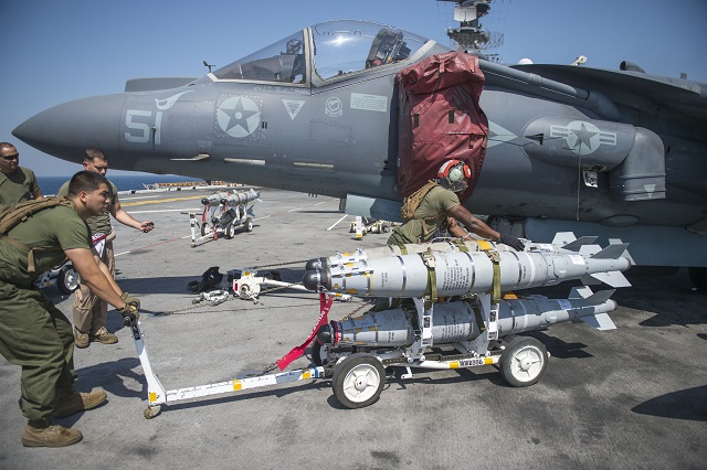 Marines assigned to Marine Medium Tiltrotor Squadron (VMM) 163, Reinforced, transport GBU-54 JDAM bombs on the flight deck of the amphibious assault ship USS Makin Island (LHD 8) for loading on an AV-8B Harrier jet. The BRU-70/A DITER provides Harriers with a smart weapon triple-carriage and employment capability, while retaining the legacy stores interface, prolonging and expanding the aircraft’s mission. (U.S. Navy photo by Mass Communication Specialist 2nd Class Christopher Lindahl/Released) 