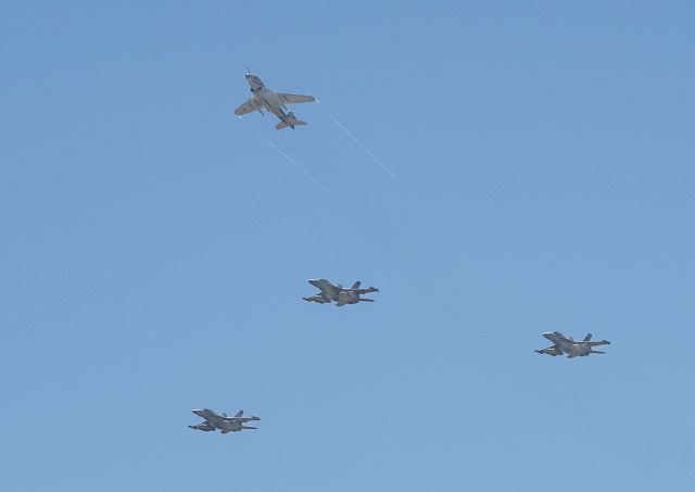 Three U.S. Navy EA-18G Growlers (bottom) and an EA-6B Prowler aircraft perform a "missing man" formation as part of a memorial ceremony held June 26 at Naval Air Station Whidbey Island. The ceremony celebrated the lives of all the naval aviators and maintenance personnel who died serving the electronic attack mission of the Prowler. Photo by Edgar Mills, Northrop Grumman